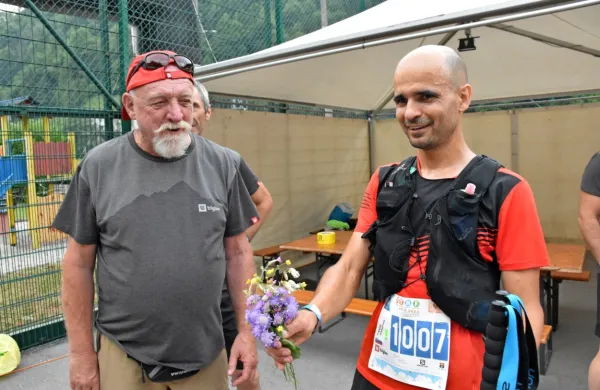 Zmagovalec 103-kilometrskega teka Anže Sobočan (desno) je po 
čestitkah vodje prireditve Jožeta Dakskoblerja še pred odličjem 
prejel tudi zasluženi planinski šopek.
