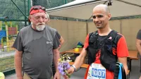 Zmagovalec 103-kilometrskega teka Anže Sobočan (desno) je po 
čestitkah vodje prireditve Jožeta Dakskoblerja še pred odličjem 
prejel tudi zasluženi planinski šopek.