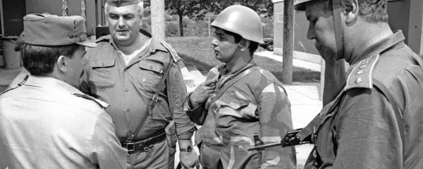 Slavko Gerzelj (levo) na fotografiji Davorina Križmančiča med pogajanji z oficirji JLA 
na mejnem prehodu Pesek. Kasneje je z nasmehom razvil slovensko zastavo.