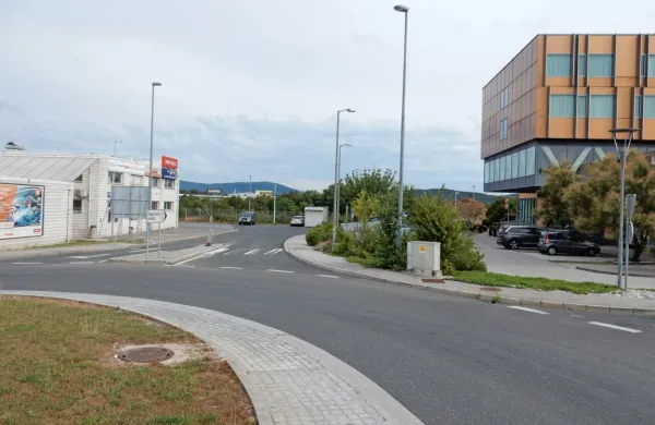 Novo krožišče bo zgrajeno na  kamionski cesti (v ozadju za 
parkiranima avtomobiloma med med  Petrolovo črpalko in hotelom Safir. Nanj bo speljan tovorni promet s  Terminala (za levim 
avtomobilom)   in iz logističnega centra (kupi zemlje za Safirjem). 