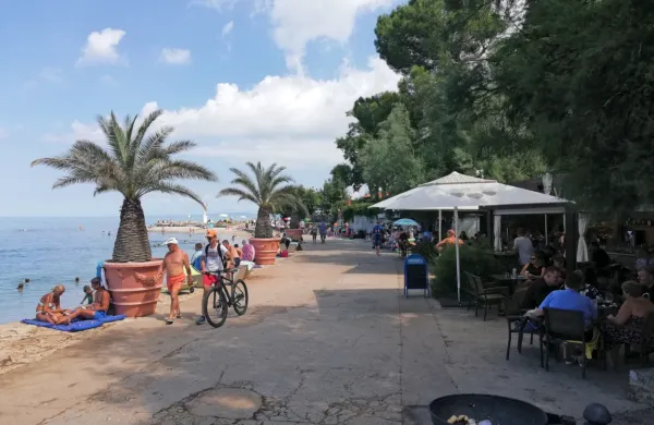 Promenada do Svetilnika v Izoli je že postala del kopaliških  
površin, zato v bližnjih baru in restavraciji obiskovalcem dovolijo,  
da   za mize  na terasi čez dan sedejo tudi v kopalkah.