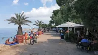 Promenada do Svetilnika v Izoli je že postala del kopaliških  
površin, zato v bližnjih baru in restavraciji obiskovalcem dovolijo,  
da   za mize  na terasi čez dan sedejo tudi v kopalkah.