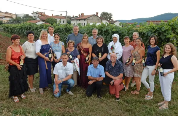 Aktualna kraljica terana Nuša Živec (z lento), levo ob njej prva kraljica Olga Milič in ob njiju še devet kraljic : Andreja Živic, Breda Durcik, 
Jožica Tavčar, Sabina Gulič, Tanja Pangerc, Majda Marc, Maruša Rogelja, Katrin Štoka in Tinkara Gulič. Med njimi   Majda Brdnik (druga 
z leve), in David Štok (kleči v sredini), župana občin Sežana in Komen, ki podpirata izbor,  ter organizatorji Meseca terana in pršuta

 