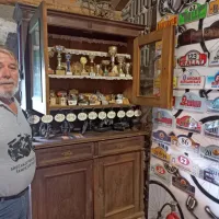 Franc Tomšič ob številnih pokalih in priznanjih, ki jih je prejel na 
srečanjih ljubiteljev starodobnikov.    