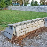 Izruvana težka kamnita klop v parku pri šoli v Sežani. 