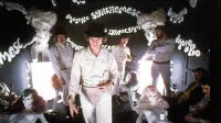 Stanley Kubrick je v vlogi Alexa videl le Malcolma McDowella (v 
ospredju). Če bi ta odklonil sodelovanje, morda Kubrick ne bi 
nikoli posnel enega od svojih najbolj kontroverznih filmov.