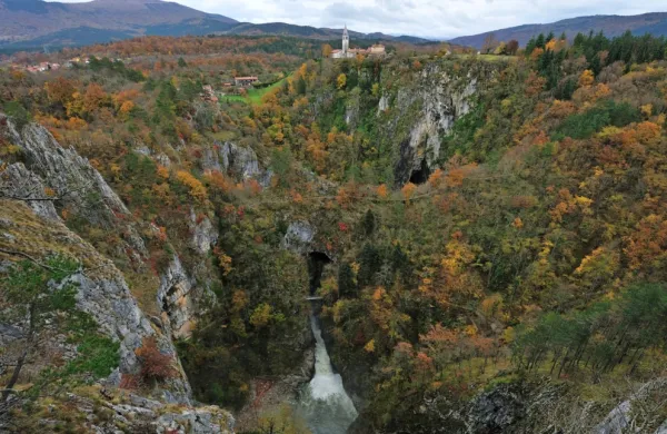 Velika dolina v jesenskih barvah s Škocjanom v ozadju.