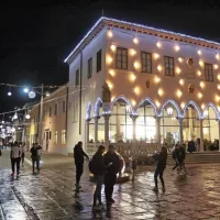 Praznično žareče pročelje Loggie in okrašena Verdijeva ulica.