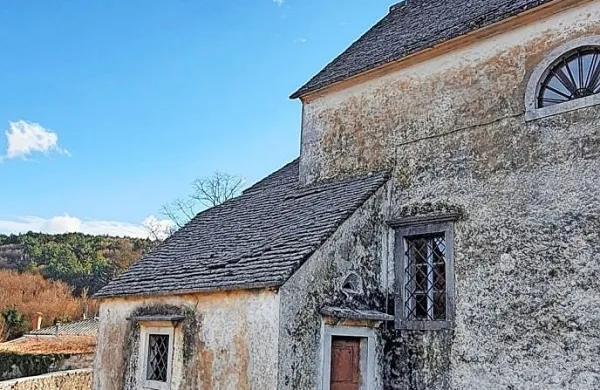 Kamnita streha zakristije ob cerkvi sv. Andeja v Merčah zamaka na 
spoju s cerkvijo, pa tudi v sredini, kjer so se skrle udrle.