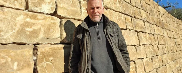 Dejan Zadravec v Koštaboni ob najnovejši kamniti stvaritvi - tri 
metra visokem suhozidu. 