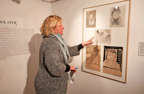 Direktorica Pilonove galerije Tina Ponebšek pred risbami, na 
katerih je Melito Vovk  med njenim obiskom Pariza upodobil tudi 
Veno Pilon.