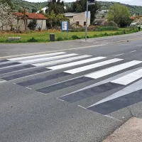 Prehod je videti kot navidezna ovira na cestišču, zaradi česar 
vozniki dodatno zmanjšajo  hitrost, ki je na tem območju že 
omejena.