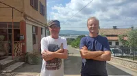 Marino Legovič in Metod Mezek na Rožniku, od koder se  vidi 
avtomobile v Luki Koper in prah s terminala za premog ter sliši 
hrup velikih ladij za prevoz avtomobilov.