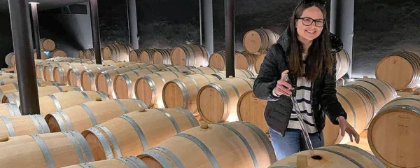 Neža Skrt v svojem delovnem okolju, med sodi v vinski kleti.