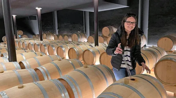 Neža Skrt v svojem delovnem okolju, med sodi v vinski kleti.