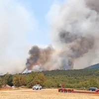 Požarišče nad cestom med Temnico in Trsteljem nenehno preletava pet helikopterjev, ki odmetavajo vodo.
