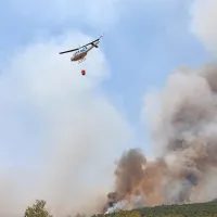 Požarišče nad cestom med Temnico in Trsteljem nenehno preletava pet helikopterjev, ki odmetavajo vodo.