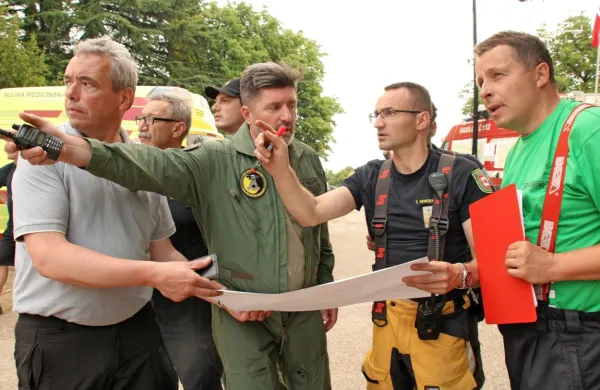Vendramin (drugi z desne) z zemljevidom v rokah vojaškim pilotom kaže, kje potrebuje pomoč iz zraka.