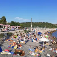 ... in plaža Caravella na njegovi desni strani. 