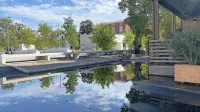 V ospredju je začasno jezerce na Muzejskem trgu, v ozadju zaradi 
suše nedelujoč vodomet in  desno dostop do hostla ter  stanovanja.