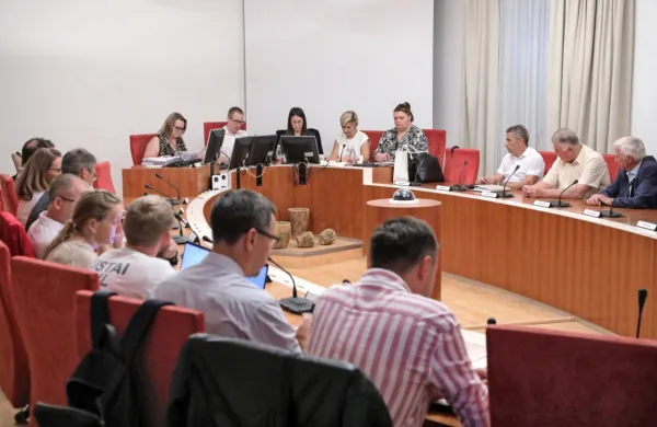 Dražitelji v ospredju fotografije so se potegovali za parcele na 
Šaredu, Miloš Milivojević (tretji z desne na nasprotni strani) pa je 
kupil zemljišča ob hotelu Delfin. Dražbo  je vodil odvetnik Dean 
Babič (z očali v ozadju fotografije).