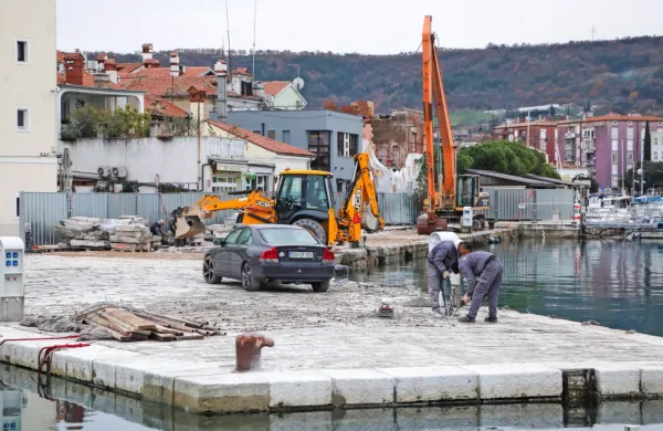 Delavci na malem pomolu odstranjujejo kamne in jih označujejo.  
Pomol bodo razširili za tri metre in pol in zvišali za skoraj pol 
metra.   