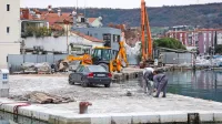 Delavci na malem pomolu odstranjujejo kamne in jih označujejo.  
Pomol bodo razširili za tri metre in pol in zvišali za skoraj pol 
metra.   