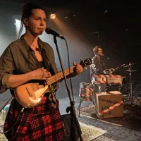 V Godzilla  Tribute Bandu, uvrščenem v   spremljevalni program, 
nastopajo Maja Poljanec Nemec, Miha Bezeljak in Zoran Petrovič.