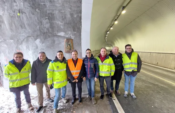 Prekomejni prijatelji in delavci Anasa (v sredini Valter Mlekuž in 
Stafano Mazzolini) pred sliko na lesu v obnovljenem predoru 
Rabelj. 