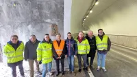 Prekomejni prijatelji in delavci Anasa (v sredini Valter Mlekuž in 
Stafano Mazzolini) pred sliko na lesu v obnovljenem predoru 
Rabelj. 