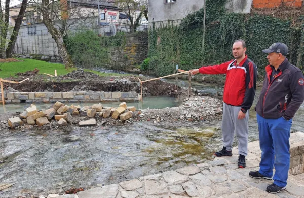 Zgrožena gospodar Ribiške družine Bistrica Nejc Udovič (levo) in ribogojec Damir Šircelj opozarjata na 
sporen betonski zid v strugi. 
