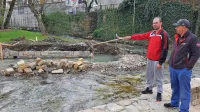 Zgrožena gospodar Ribiške družine Bistrica Nejc Udovič (levo) in ribogojec Damir Šircelj opozarjata na 
sporen betonski zid v strugi. 