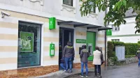 Kriminalisti so na vhodnih vratih iskali sledi za roparjema. 