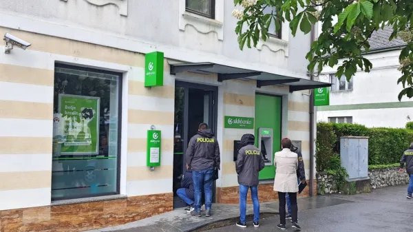 Kriminalisti so na vhodnih vratih iskali sledi za roparjema. 