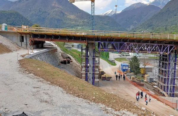 Kolesarska steza poteka pod mostom in naprej čez brv  nad Tolminko in proti Mostu na Soči. 