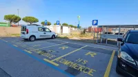 Niz rezerviranih parkirnih mest ob poslovni stavbi na Ankaranski 
cesti.