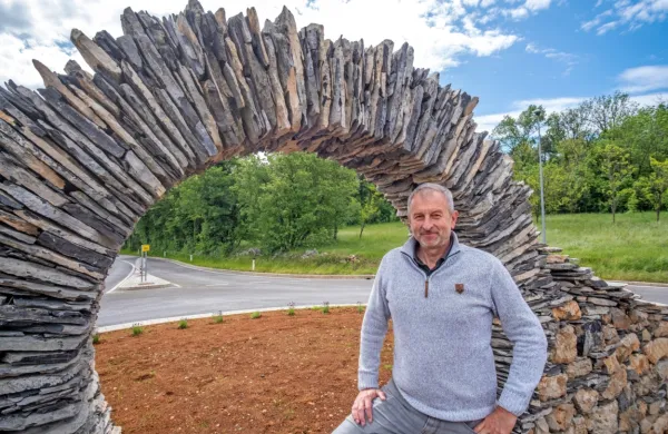 Župan Erik Modic ob kamniti skulpturi na edinem krožišču v 
občini.