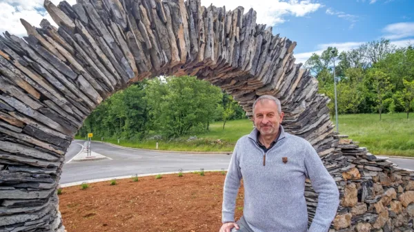 Župan Erik Modic ob kamniti skulpturi na edinem krožišču v 
občini.
