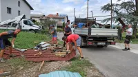 Več kot 50 domačinov je dan po tornadu združilo moči pri 
pospravljanju razdejanja v vasi.