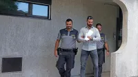 Gero  Mladenova  (na  sredini)  sta  pravosodna  policista  pripeljala na  
sodišče  iz  pripora,  v  katerem je  od januarja.
