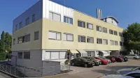 V prizidku v vrhnji etaži v ospredju fotografije bodo  center za krepitev zdravja, klinična psihologinja, sejna 
soba,  kabineti in  pisarne, v  prizidku skrajno desno pa bo nova telovadnica za fizioterapijo.  