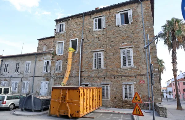 Skozi  gradbiščni tunel nadzorovano odstranjujejo ostanke starega 
pohištva, predelne stene in vso kramo, ki je ostala za zadnjimi 
stanovalci.