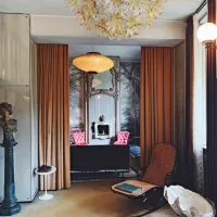 Pogled iz &ldquo;jedilnice&rdquo; proti preostalima deloma dnevnega prostora, posejanega z najrazličnej&scaron;im pohi&scaron;tvom in kuriozitetami.