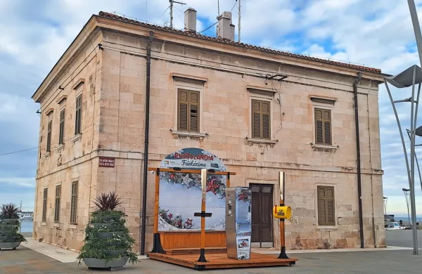 Prostor za fotografiranje  zakriva pogled na kulturno dediščino, 
klasicistično-baročno enonadstropno stavbo iz klesancev belega 
istrskega kamna, ki so jo zgradili v prvi četrtini 18. stoletja. 

