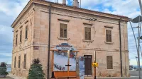 Prostor za fotografiranje  zakriva pogled na kulturno dediščino, 
klasicistično-baročno enonadstropno stavbo iz klesancev belega 
istrskega kamna, ki so jo zgradili v prvi četrtini 18. stoletja. 


