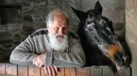 Pater Karel Gržan ob kobili Kapri, ki mu dela družbo že 15 let in s katero je med avgustovskimi poplavami preživel najhujše ure svojega življenja. 
