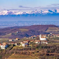 Pogled na Vedrijan in Višnjevik (v ozadju) z zasneženo kuliso  
Karnijskih Alp 

