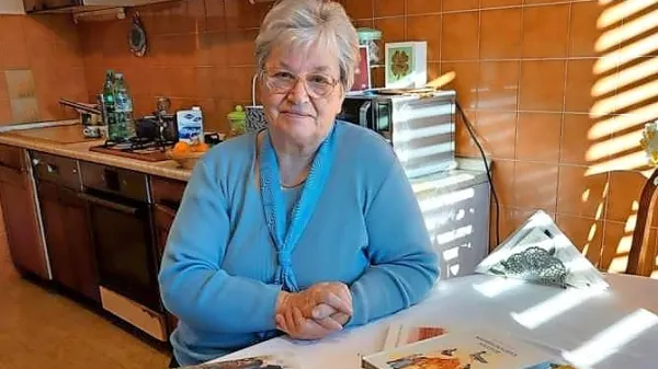 Jasna Majda Peršolja ob svoji bogati zbirki knjig.