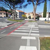 Primer zgledno urejenega talno taktilnega vodilnega sistema na 
krožišču v Izoli: talne oznake nakazujejo, kje je prehod za pešce,  
črte pa slepe vodijo čez prehod.   