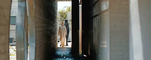 Florence Pugh v ospredju  kot princesa Irulan v propylonu, v ozadju 
ena od benegesseritinj (Charlotte Rampling). 